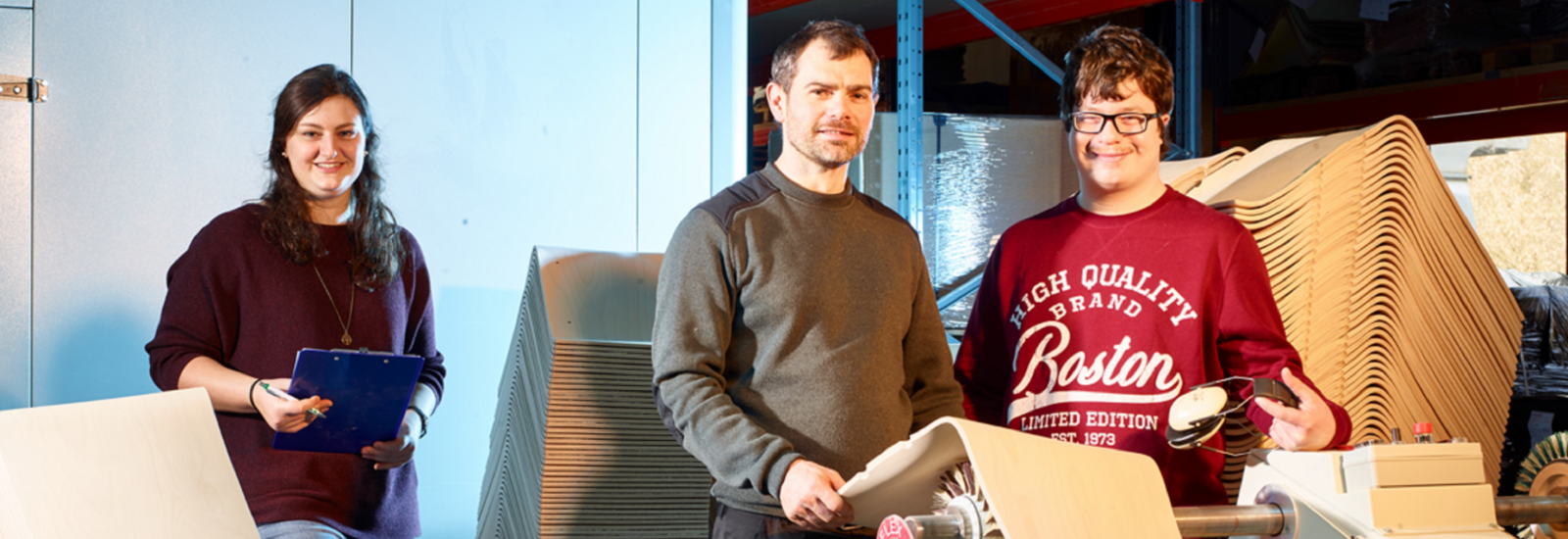 Beraterin des Integrationsfachdienstes besucht einen Mitarbeiter mit Schwerbehinderung an seinem Arbeitsplatz in einem Produktionsbetrieb